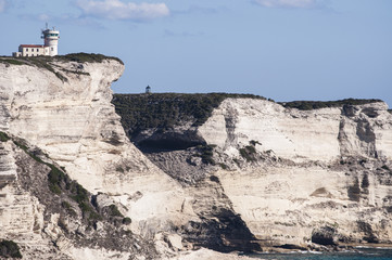 Corsica, 05/09/2017: le bianche scogliere di Bonifacio nella riserva naturale del Parco internazionale delle Bocche di Bonifacio, con vista del faro di Capo Pertusato © Naeblys