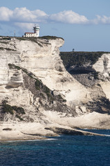 Corsica, 05/09/2017: le bianche scogliere di Bonifacio nella riserva naturale del Parco internazionale delle Bocche di Bonifacio, con vista del faro di Capo Pertusato © Naeblys