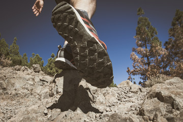 Close up of hikers legs, walking in rocky mountains.