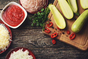 Raw ingredients for baking zucchini, stuffed with minced meat, tomato and cheese.