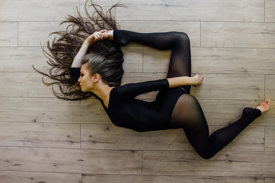 Beautiful young model ballet dancer lying inon floor. Top view.