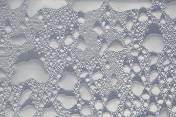 Regentropfen auf einer weissen Parkbank