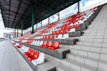 Empty seats of red and white in the stands of the race track