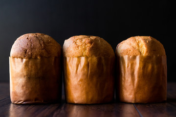 Panettone Breads on Dark Wooden Surface.