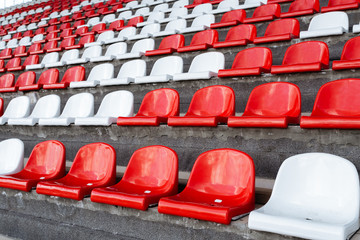 Empty seats of red and white in the stands of the race track