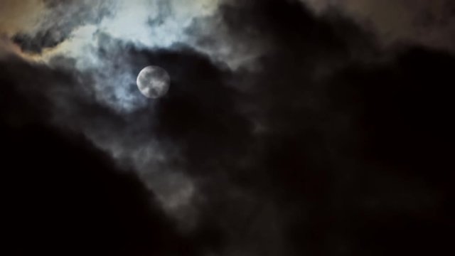 Full moon in the night sky, full moon, night sky, the motion of clouds in the night sky against the background of a bright moon,