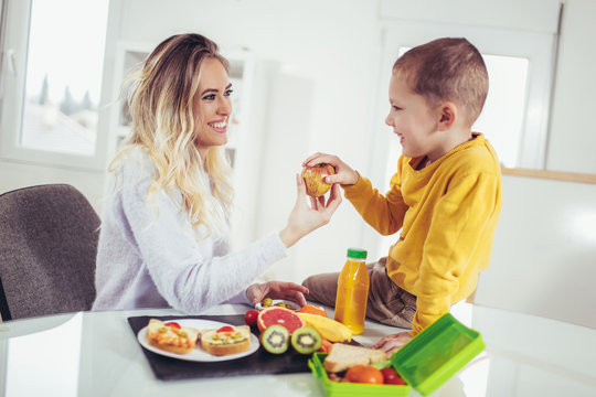 Mother Making Breakfast For Her Children In The Morning And A Snack For School