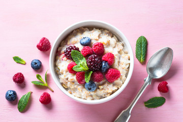 Oatmeal cereal with milk and berries top view. - obrazy, fototapety, plakaty
