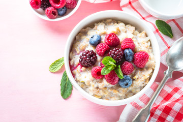 Oatmeal porrige with milk and berries top view.