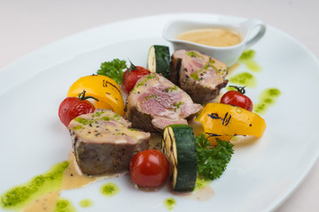 Beef with roasted vegetables in the background sauce