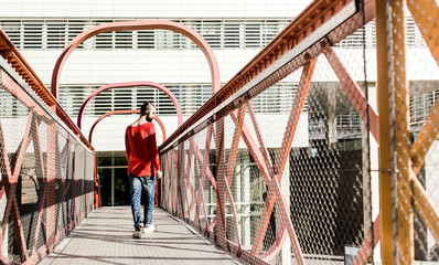 Man with headphones on a bridge
