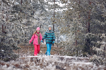 young boy and girl walking in snowy mountain
