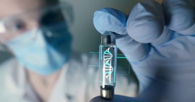 A scientist in his laboratory holds a test tube containing DNA and is able to control the evolution of man thanks to holography. Concept of: DNA, technology, augmented reality.