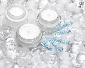 Obraz na płótnie Canvas Cooling effect skin care creams surrounded by ice cubes