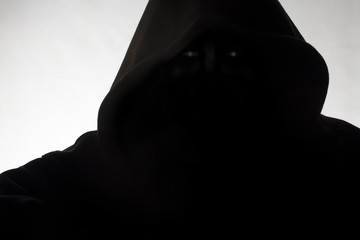 Man in hood / Hooded man in shadow on white background.