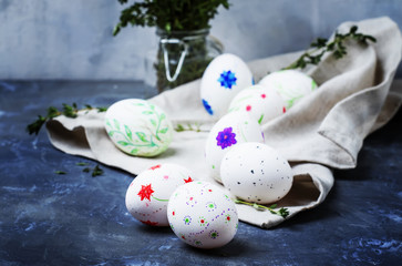 Easter spring composition, white eggs with a primitive pattern by hand, gray background, selective focus