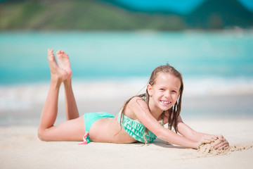 Adorable little girl at beach having a lot of fun in shallow water
