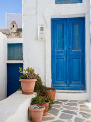 Fototapeta na wymiar A small traditional blue door with somea clay pots in front