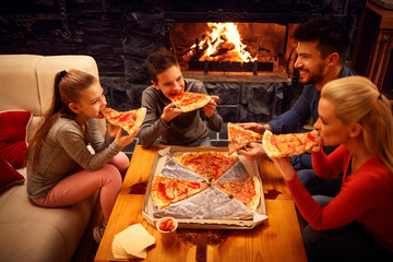 Happy family eating pizza slices for the dinner