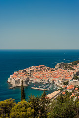 Naklejka premium Spectacular picturesque view on the old town (medieval Ragusa) and Dalmatian Coast of Adriatic Sea. Picture taken from the mountain trails above Dubrovnik citadel, Famous European Travel Destination.