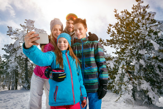 Winter, ski, snow and fun - family enjoying ski holiday. Mobile photo. Selfie