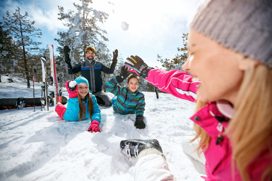 family playing on snow in ski resort