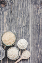 Rice and flour in glass jars on wooden rustic background. Top view, copy space.