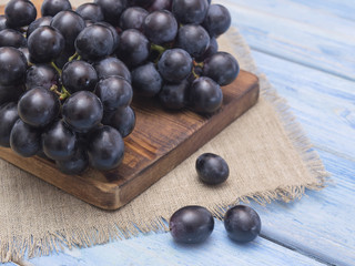 a bunch of grapes on a blue wooden background. 