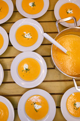 Plates with pumkin soup being prepared