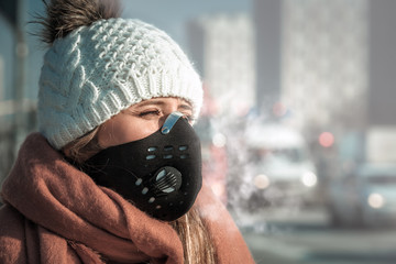 Young woman wearing protective mask in the city street, smog and air pollution - obrazy, fototapety, plakaty