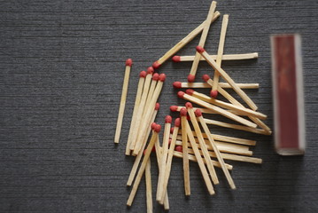 Matches scattered on a dark background 