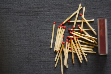 Matches scattered on a dark background 