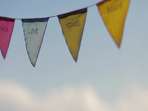 colorful line of triangle flags with Love message buddhist style and blue sky behind
