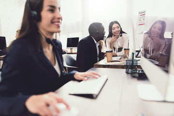 Obraz premium Two girls who work as operators in the call center talk to a black guy.