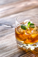 Glass of rum on the wooden background