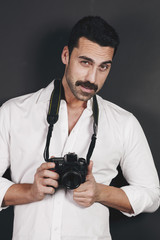 Young handsome photographer with beard and mustache studio portrait