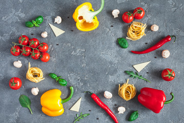 Ingredients for cooking pasta on black background. Fettuccine, fresh vegetables, cheese, mushrooms, spice. Italian food concept. Flat lay, top view, copy space