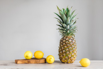 Pienaple and lemons on white background