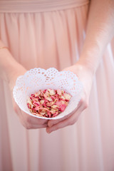 Small Pink Flower Petal Confetti in White Doily Cone being held in Hands