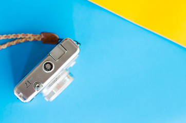 Top view of vintage camera on two color blue and yellow background,