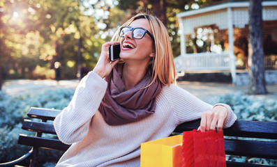 Young woman resting in the park after shopping. Consumerism, lifestyle concept