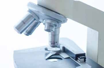Close-up shot of microscope with metal lens at laboratory. Scientific and healthcare research background.