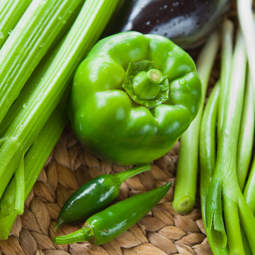 Green vegetables board - bell pepper, spicy green chili, leeks, spring onions, scallions, chives, calery, courgette.