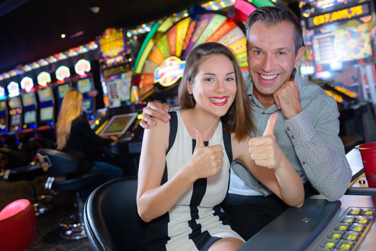 Couple giving thumbs up in casino