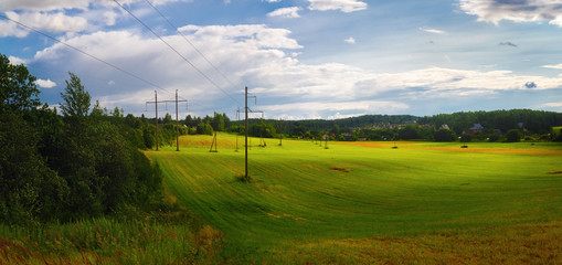 Panoramic rural landscape. Field of green grass and sky with clouds. Panorama shot.