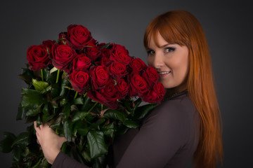 Young woman with ginger hair on international womens day with a lot of flowers