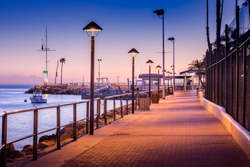 Brick walkway to boat dock in early sunrise light, streelights on, shadows, quiet, calm peaceful, Avalon, Santa Catalina Island, California - obrazy, fototapety, plakaty