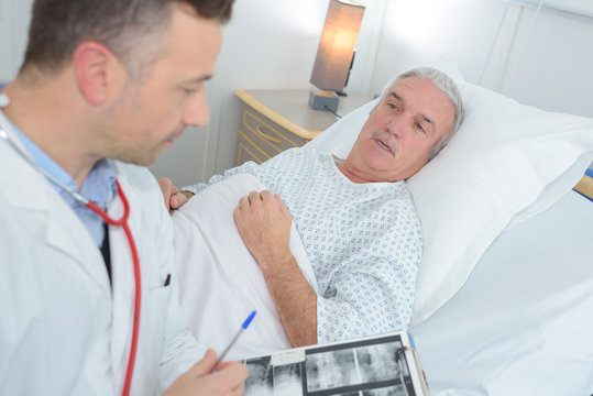 male doctor standing next to the patient and holding results