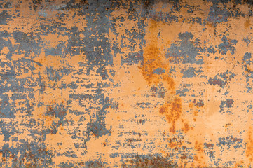 Textured background of a faded yellow paint with rusted cracks on rusted metal. Grunge texture of an old cracked metal surface. Rusty yellow-red stains