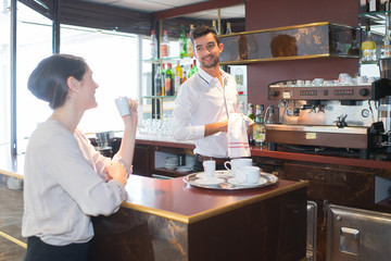Obraz na płótnie Canvas bartender with customer holding a cup of coffee